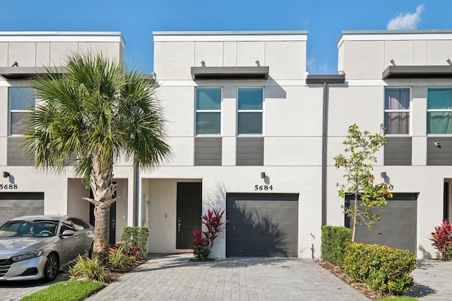 5684 Mentmore Dr, Mangonia Park, FL 33407 - view of front of property with a garage, stucco siding, and decorative driveway