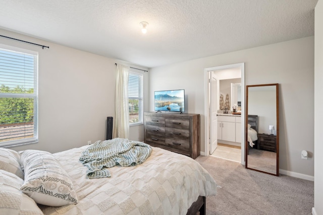 5684 Mentmore Dr, Mangonia Park, FL 33407 - bedroom featuring baseboards, ensuite bathroom, light colored carpet, and a textured ceiling
