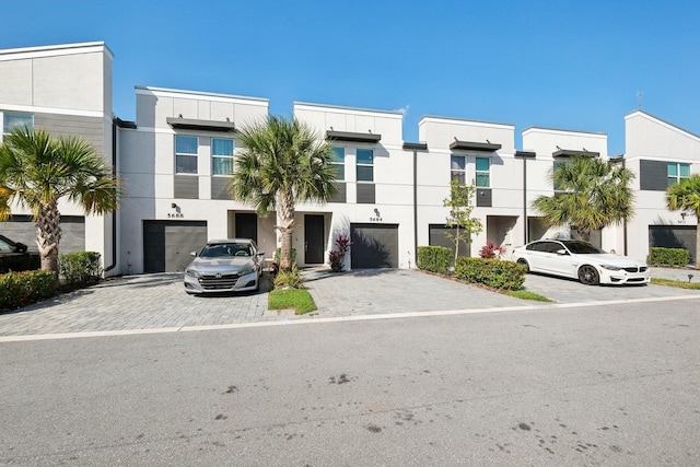 5684 Mentmore Dr, Mangonia Park, FL 33407 - townhome / multi-family property featuring a garage, driveway, and stucco siding