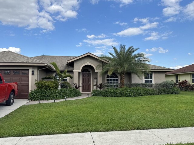 215 Monterey Way, Royal Palm Beach, FL 33411 - ranch-style house featuring an attached garage, stucco siding, a front yard, and concrete driveway