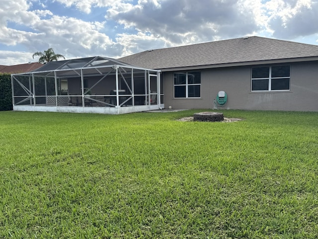 215 Monterey Way, Royal Palm Beach, FL 33411 - back of property with stucco siding, a lawn, a fire pit, and roof with shingles
