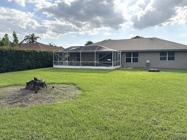 215 Monterey Way, Royal Palm Beach, FL 33411 - rear view of house with an outdoor fire pit, a lawn, glass enclosure, and stucco siding