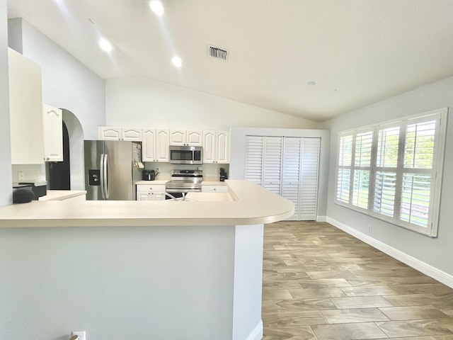 215 Monterey Way, Royal Palm Beach, FL 33411 - kitchen with appliances with stainless steel finishes, lofted ceiling, light countertops, arched walkways, and white cabinets