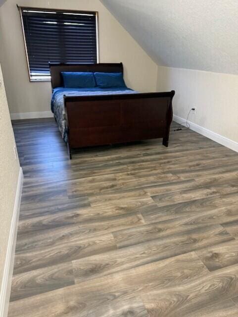 795 SW All American Blvd, Palm City, FL 34990 - bedroom with lofted ceiling, baseboards, and wood finished floors