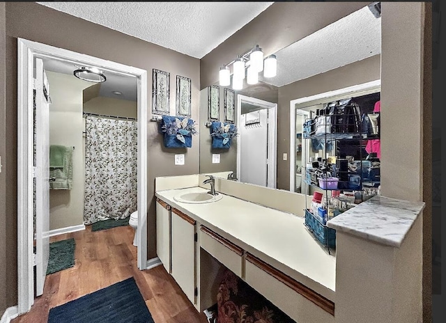3696 Timberline Dr, West Palm Beach, FL 33406 - bathroom featuring a textured ceiling, vanity, toilet, wood finished floors, and baseboards