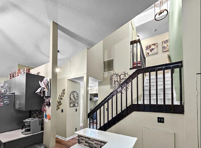 3696 Timberline Dr, West Palm Beach, FL 33406 - stairs with a textured ceiling, high vaulted ceiling, baseboards, and visible vents