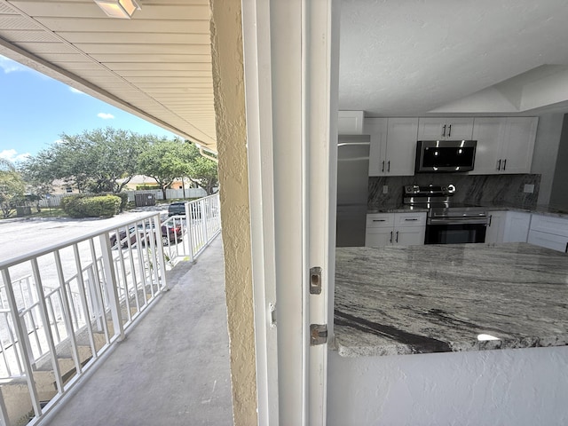 208 Palm Beach Trace Dr, Royal Palm Beach, FL 33411 - kitchen featuring appliances with stainless steel finishes, backsplash, concrete floors, stone countertops, and white cabinets