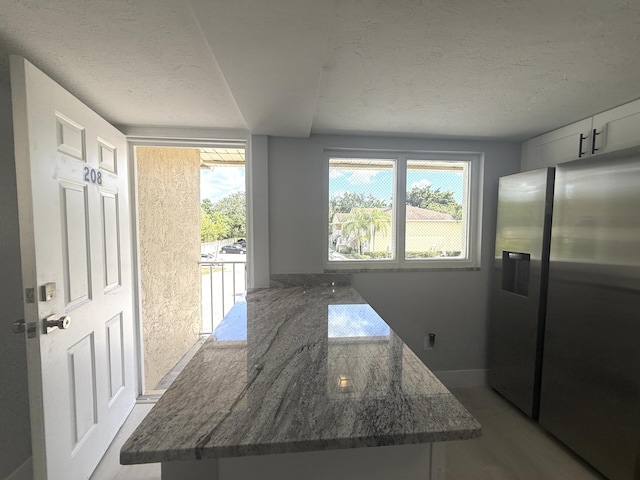 208 Palm Beach Trace Dr, Royal Palm Beach, FL 33411 - kitchen featuring a textured ceiling, dark stone countertops, healthy amount of natural light, wood finished floors, and stainless steel refrigerator with ice dispenser