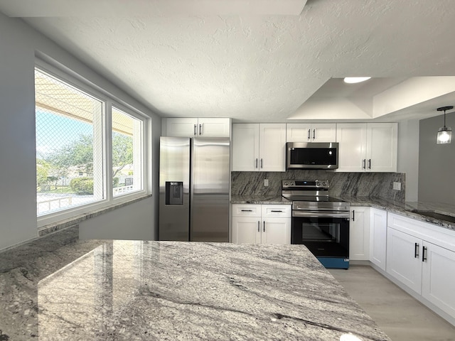 208 Palm Beach Trace Dr, Royal Palm Beach, FL 33411 - kitchen with appliances with stainless steel finishes, backsplash, white cabinets, light stone countertops, and light wood-type flooring