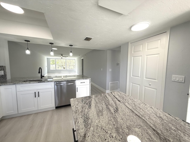 208 Palm Beach Trace Dr, Royal Palm Beach, FL 33411 - kitchen with dishwasher, a sink, light wood-style flooring, white cabinets, and a textured ceiling