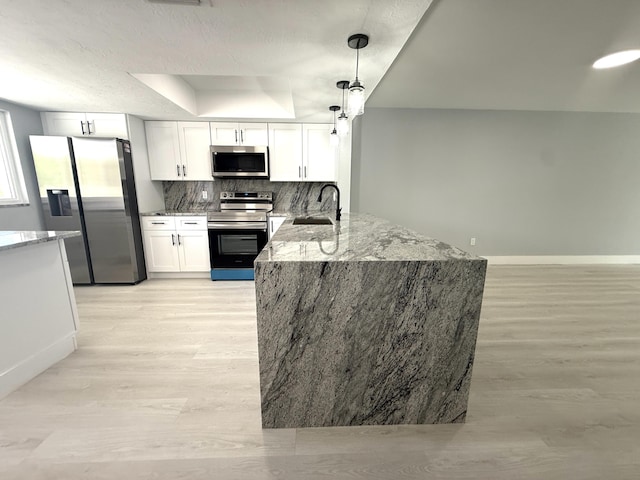 208 Palm Beach Trace Dr, Royal Palm Beach, FL 33411 - kitchen featuring appliances with stainless steel finishes, light wood-type flooring, a sink, a peninsula, and light stone counters