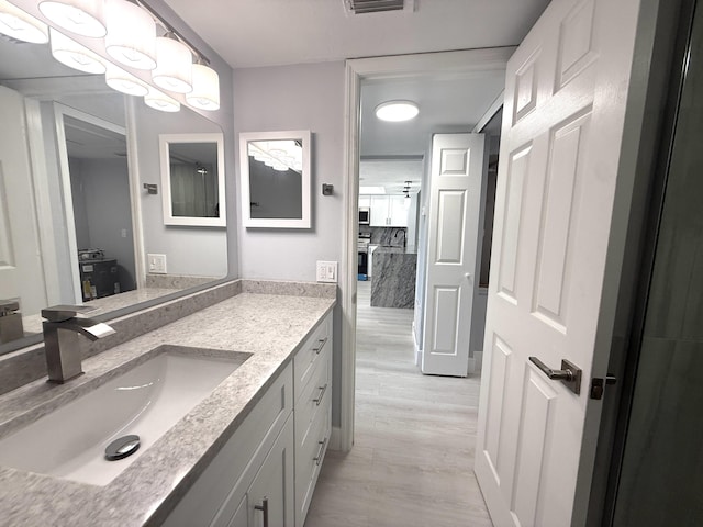 208 Palm Beach Trace Dr, Royal Palm Beach, FL 33411 - bathroom featuring wood finished floors and vanity