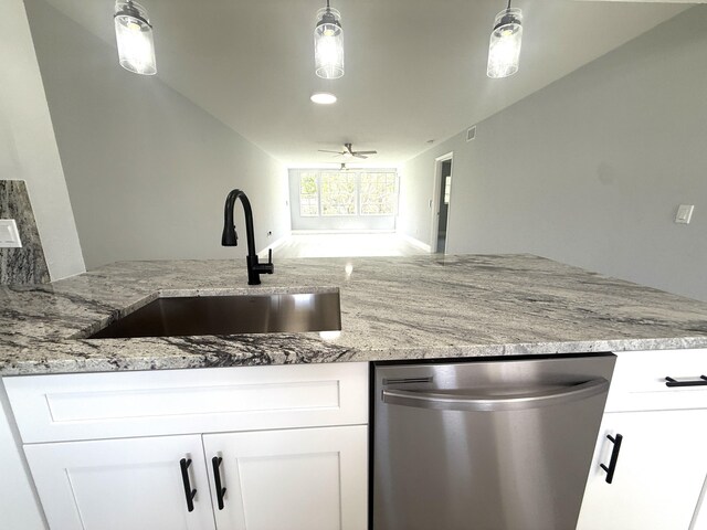 208 Palm Beach Trace Dr, Royal Palm Beach, FL 33411 - kitchen featuring dishwasher, a sink, light stone counters, white cabinets, and decorative light fixtures