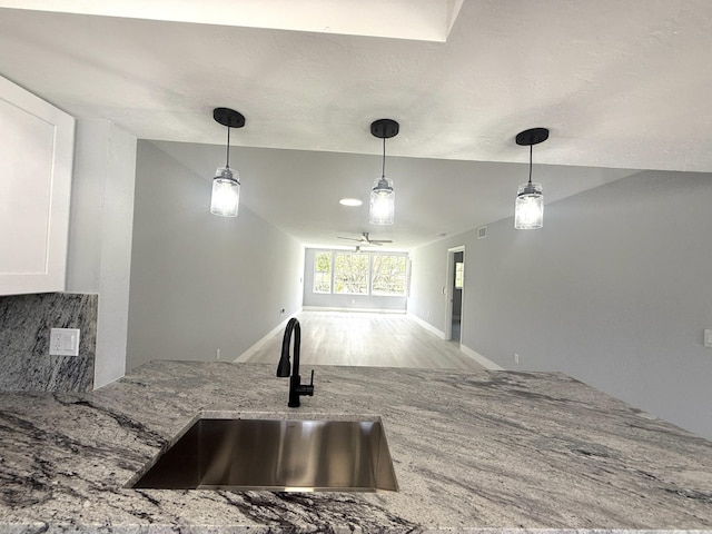 208 Palm Beach Trace Dr, Royal Palm Beach, FL 33411 - kitchen with a sink, light stone counters, decorative light fixtures, decorative backsplash, and wood finished floors