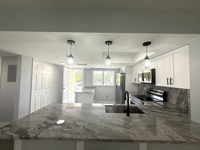 208 Palm Beach Trace Dr, Royal Palm Beach, FL 33411 - kitchen featuring stainless steel appliances, a center island, a peninsula, a sink, and light stone countertops