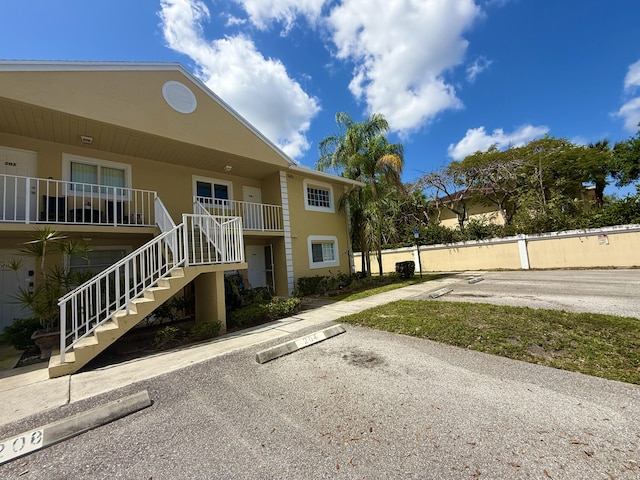 208 Palm Beach Trace Dr, Royal Palm Beach, FL 33411 - view of property with stairs and uncovered parking