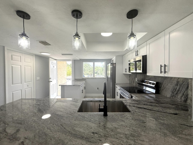 208 Palm Beach Trace Dr, Royal Palm Beach, FL 33411 - kitchen featuring appliances with stainless steel finishes, a sink, a center island, and light stone countertops
