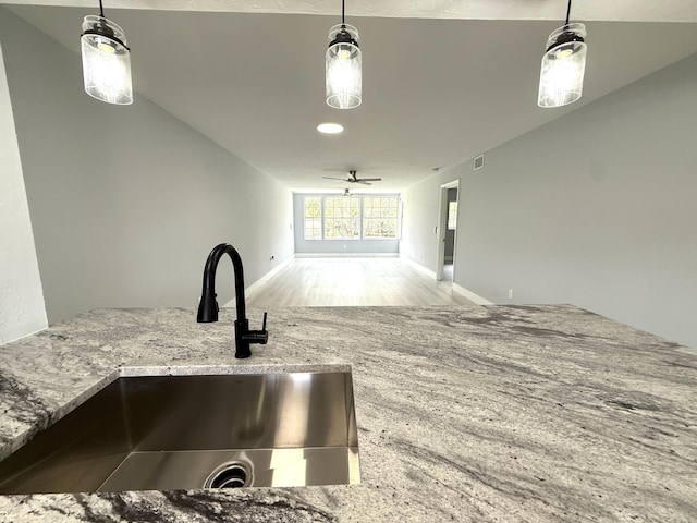 208 Palm Beach Trace Dr, Royal Palm Beach, FL 33411 - interior space with a sink, light stone counters, hanging light fixtures, wood finished floors, and baseboards