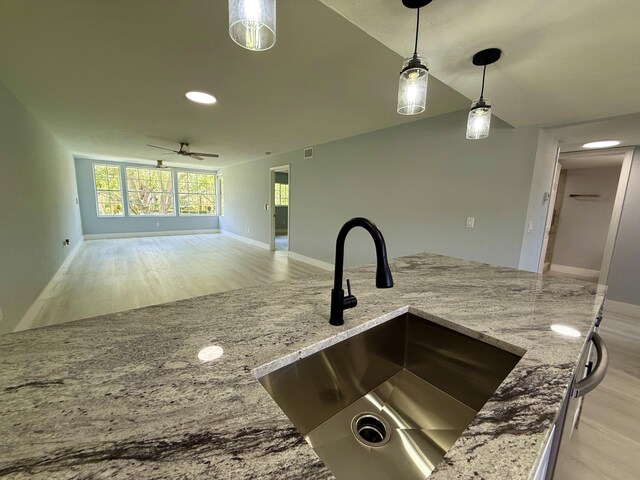 208 Palm Beach Trace Dr, Royal Palm Beach, FL 33411 - kitchen featuring a sink, ceiling fan, light stone countertops, light wood finished floors, and pendant lighting