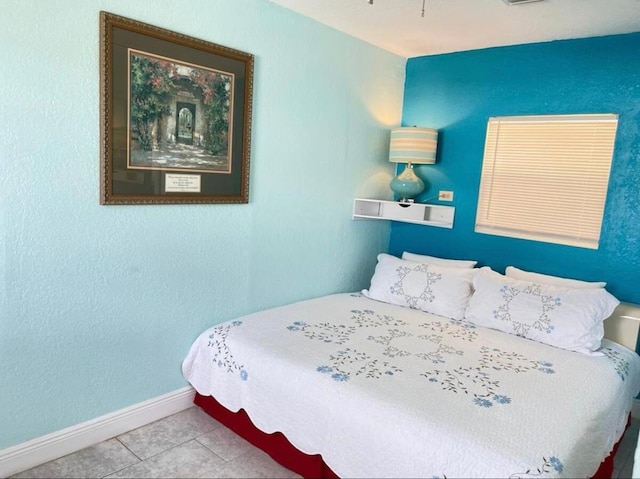tiled bedroom featuring baseboards