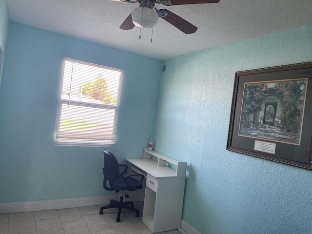 office area featuring light tile patterned floors, a textured ceiling, a ceiling fan, and baseboards
