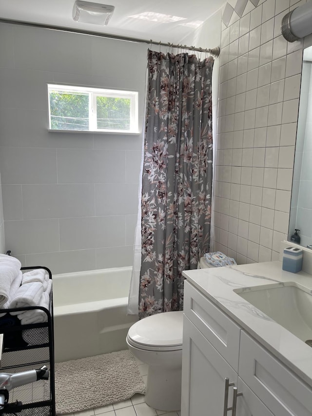 full bath with tile walls, shower / bathtub combination with curtain, vanity, tile patterned floors, and toilet