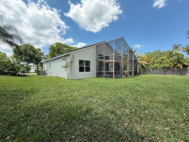 4803 NW 59th Ct, Coconut Creek, FL 33073 - back of house with fence, a yard, stucco siding, and a lanai