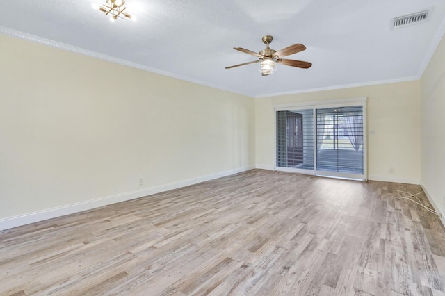 empty room featuring baseboards, visible vents, a ceiling fan, wood finished floors, and ornamental molding