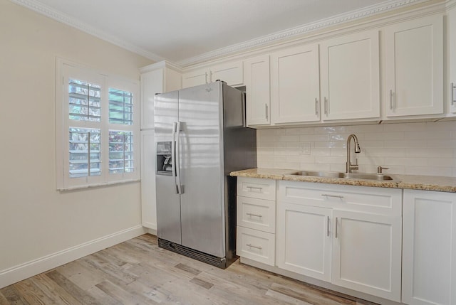kitchen with crown molding, a sink, light wood-type flooring, stainless steel fridge with ice dispenser, and backsplash