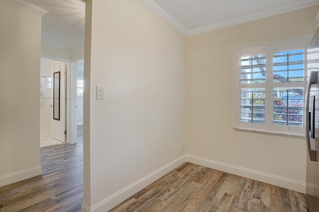 unfurnished room featuring wood finished floors, ornamental molding, and a healthy amount of sunlight