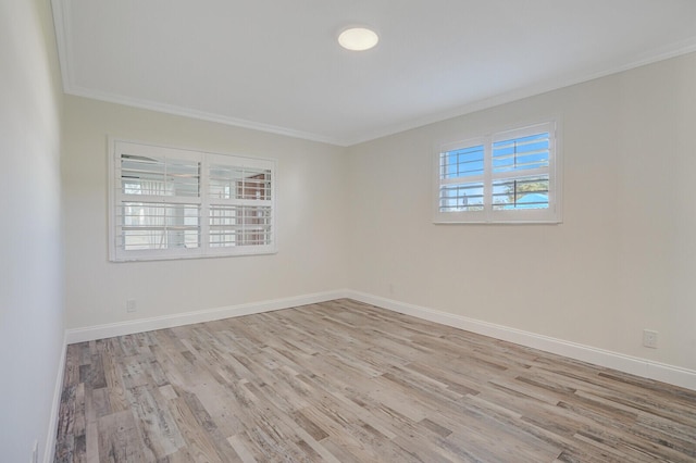 unfurnished room featuring baseboards, wood finished floors, and ornamental molding