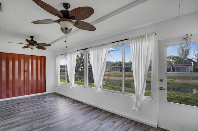 unfurnished sunroom with visible vents, a wealth of natural light, and a water view