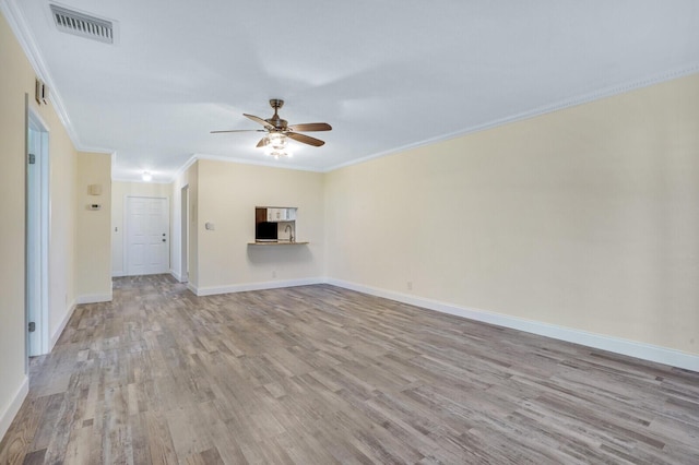 unfurnished living room with wood finished floors, visible vents, crown molding, baseboards, and ceiling fan