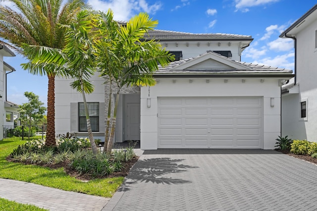 3038 Safflower Cir, West Palm Beach, FL 33401 - view of front of property featuring an attached garage, driveway, stucco siding, and a tiled roof