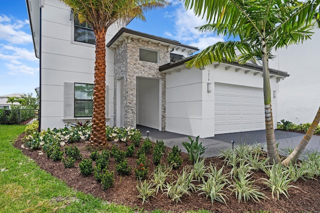3038 Safflower Cir, West Palm Beach, FL 33401 - modern home featuring stone siding, a garage, and asphalt driveway