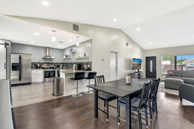 7938 Ridgewood Dr, Lake Worth, FL 33467 - dining area featuring visible vents, recessed lighting, vaulted ceiling, a barn door, and dark wood-style floors
