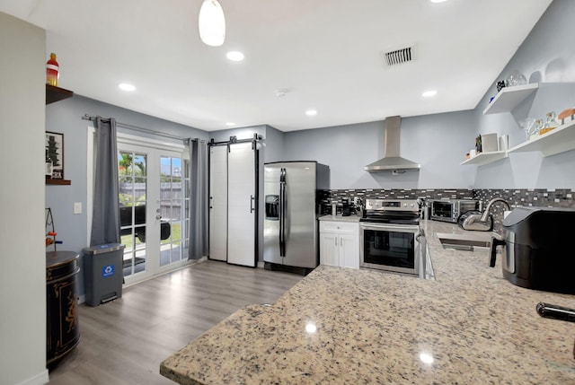 7938 Ridgewood Dr, Lake Worth, FL 33467 - kitchen featuring light stone counters, visible vents, wall chimney exhaust hood, appliances with stainless steel finishes, and a sink