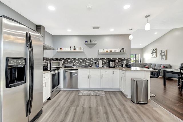 7938 Ridgewood Dr, Lake Worth, FL 33467 - kitchen with a peninsula, appliances with stainless steel finishes, open shelves, and light wood-type flooring