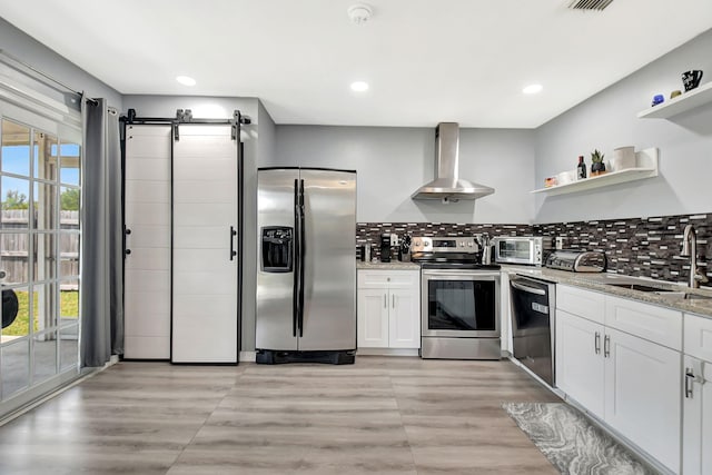 7938 Ridgewood Dr, Lake Worth, FL 33467 - kitchen featuring open shelves, plenty of natural light, a sink, wall chimney range hood, and appliances with stainless steel finishes