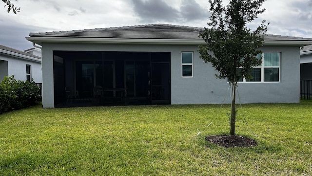 9833 SW Isabelline Dr, Port Saint Lucie, FL 34987 - rear view of house featuring a sunroom, a yard, a tile roof, and stucco siding