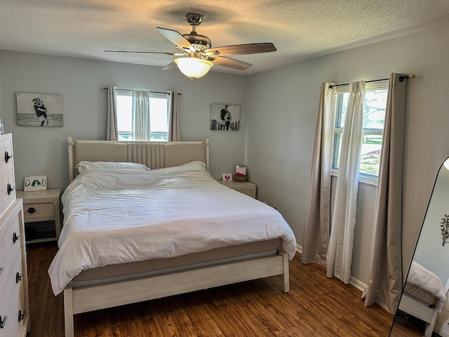 bedroom with a textured ceiling, wood finished floors, and ceiling fan