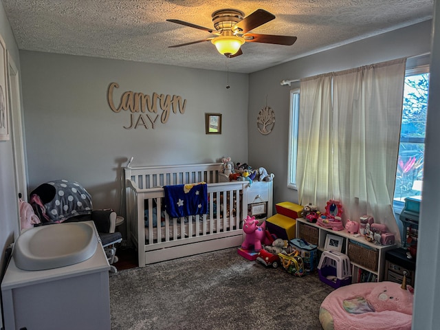 bedroom featuring multiple windows, a textured ceiling, and carpet floors