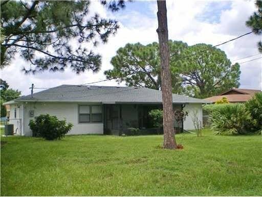 back of house with a yard and stucco siding
