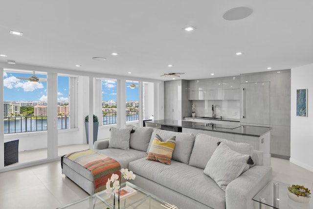 living area featuring a water view, recessed lighting, and light tile patterned flooring