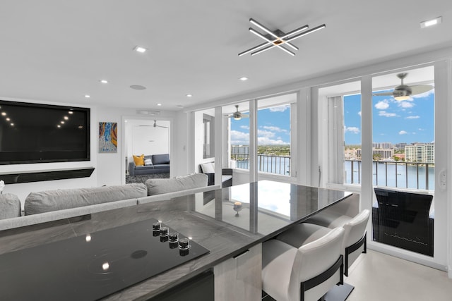 kitchen with ceiling fan, black electric stovetop, recessed lighting, open floor plan, and a water view