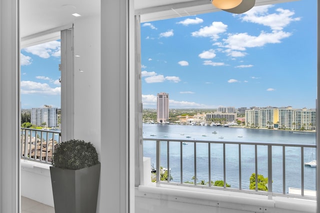 balcony featuring a water view and a city view
