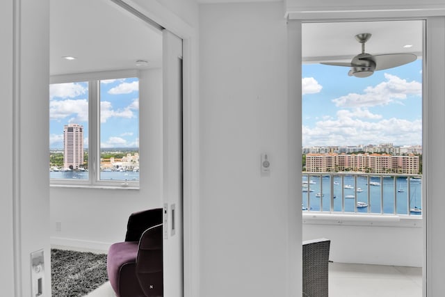 living area with a water view and a ceiling fan