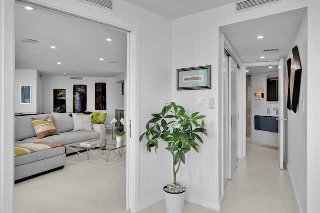 hall with baseboards, recessed lighting, and visible vents