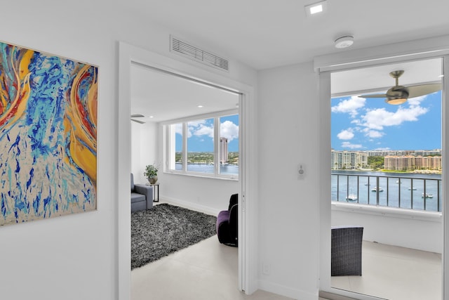 interior space with baseboards, tile patterned flooring, a water view, and visible vents