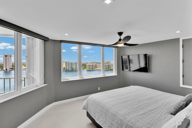bedroom featuring a view of city, a water view, and ceiling fan